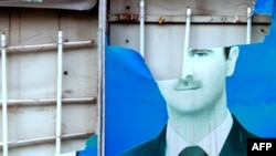 A damaged portrait of Syrian President Bashar al-Assad in the city of Qamishli.