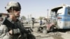 A U.S. soldier stands at the site of a bomb attack in Kirkuk on August 25. Continuing violence means the remaining 50,000 troops will still have much to do.