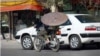 An Iranian man on a motorcycle carries a satellite dish. (file photo)