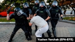 Belarusian police officers detain a demonstrator in Minsk during a protest on August 10, 2020, the day after a widely disputed presidential election. 