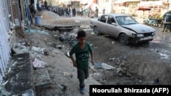 A boy walks at the site of a suicide bomb attack near a Shi'ite mosque in Kabul on September 29.