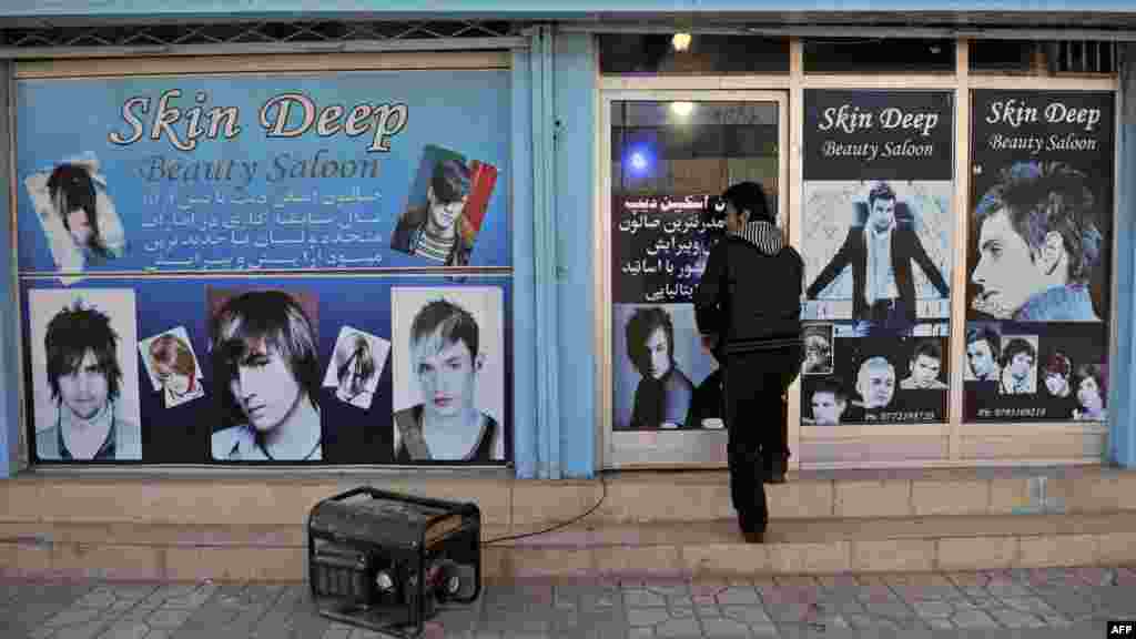 A young man enters a barber shop in Kabul in January.