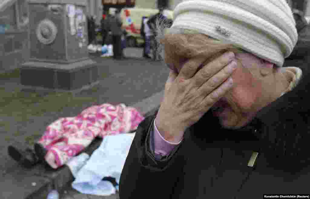 A woman cries as dead bodies are seen on the ground following violence on Independence Square in Kyiv on February 20.