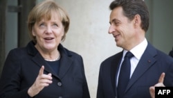 French President Nicolas Sarkozy (right) welcomes German Chancellor Angela Merkel prior to a working lunch at the Elysee Palace in Paris on December 5.