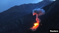 Two bombs explode at dusk on a Taliban fighting position above Kamdesh in Nuristan Province on June 11.