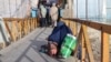 A woman and child beg on a bridge in Ghazni.