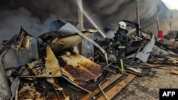 A Ukrainian rescue workers tries to extinguish a fire in a building destroyed in a Russian drone attack in Bohodukhiv, Kharkiv region, Ukraine on March 8.