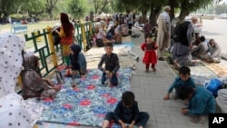 Afghan people rest on tents and blankets as they seek to receive asylum from the United Nations High Commissioner for Refugees in Islamabad on May 9, 2022. 