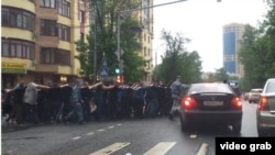 Russia - russian police officers are taking migrants to police station in the street