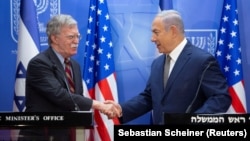 Israeli Prime Minister Benjamin Netanyahu (right) shakes hands with U.S. national-security adviser John Bolton during their meeting at the prime minister's office in Jerusalem on August 20.