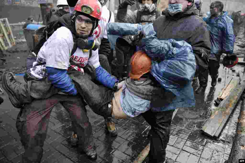 Paramedics carry a wounded protester.