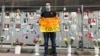 A medical worker pickets for COVID hazard payments in front of a St. Petersburg memorial for colleagues who have died of the disease.