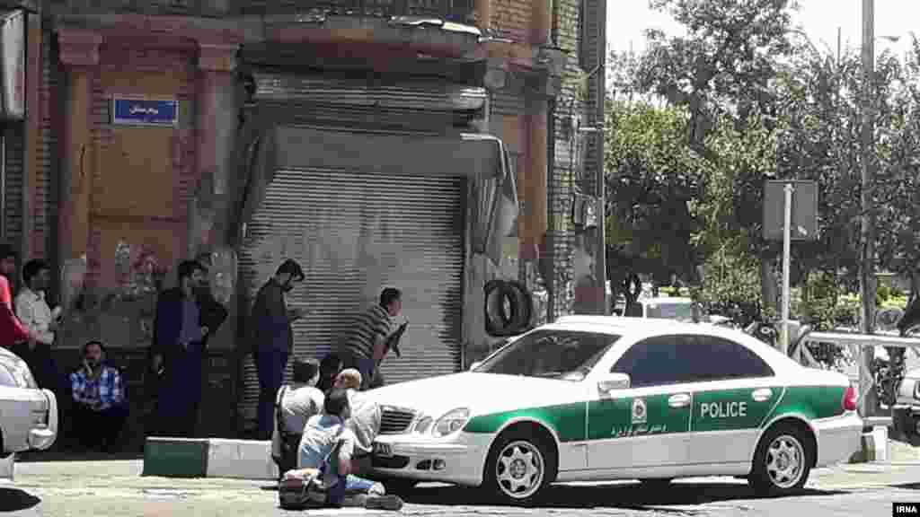 Journalists and armed police at the scene outside the Iranian parliament.&nbsp;