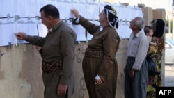 Voters read electoral lists at a polling station in the northern city of Irbil, in Iraq's Kurdistan region, on September 21.