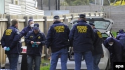 Australian forensic police inspect a car at a house in Melbourne.