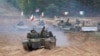 Military vehicles and tanks from Poland, Italy, Canada, and United States take part in NATO military exercises at a training ground in Latvia in September 2021.