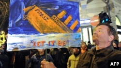 A man holds a banner with a sinking ship of the ruling Fidesz party in front of the state opera in Budapest on January 2.