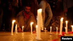 A man in Karachi lights candles to mourn the victims from the Army Public School in Peshawar, Pakistan, which was attacked by Taliban gunmen on December 16. 