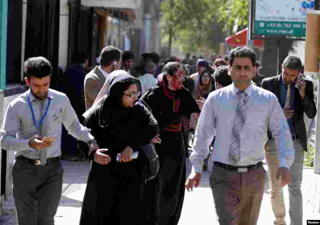 Injured Afghans run from the site of the blast.