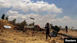 Free Syrian Army rebel fighters fire rockets towards government forces in the northern countryside of Quneitra in June this year. 